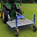 Rear view of a tractor towing the Campey UniRake on a grass sports field. The UniRake’s spring tines are designed for turf maintenance, helping to relieve compaction, improve aeration, and enhance pitch quality for football, rugby, and natural grass surfaces.