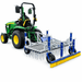 Campey UniRake – Multi-Purpose Turf Grooming Rake shown mounted behind a compact tractor on a white background, featuring spring tines, support wheels, adjustable frame and rear grooming brush.