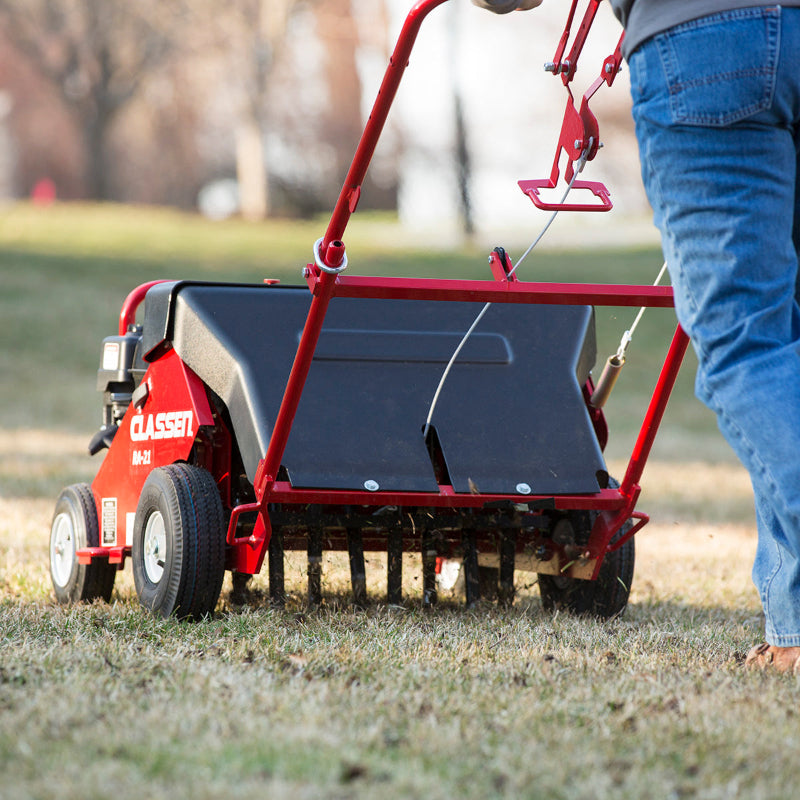 Operator using the Classen RA-21H reciprocating aerator on a grassy lawn, showcasing its deep tine penetration and efficient soil aeration performance.