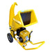 crommelin GTM Professional GTS1300RP yellow wood chipper with wide feed chute, black rubber safety flaps, curved discharge chute, sturdy wheels, and petrol engine, photographed from a left-front angle on a plain white background, ideal for processing branches and garden waste.
