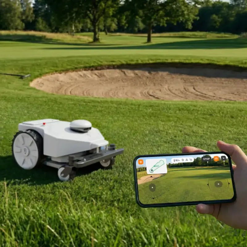 FJD FRX Robotic Lawn Mower managed through a smartphone app beside a golf course bunker, showcasing remote monitoring, route control, and autonomous commercial turf maintenance