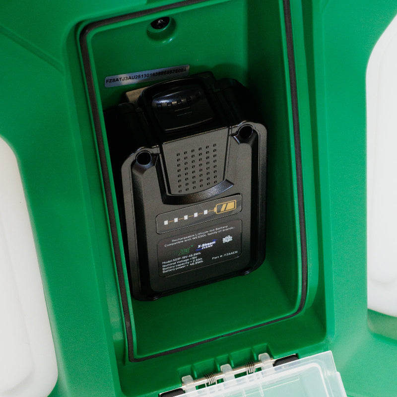 Close-up view of the FlowZone Zephyr 3 backpack sprayer’s internal battery compartment, showing the installed 18V lithium-ion rechargeable battery securely in place. The green housing with protective cover highlights the compact and organized design for safe battery storage.