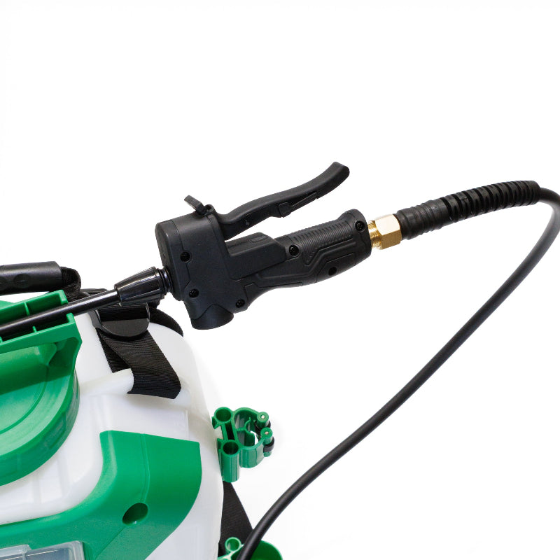 Detailed close-up view of the FlowZone Zephyr 3 sprayer’s spray wand handle and trigger, attached to a flexible hose with a brass connector. The green top of the tank and accessory holders are partially visible in the background.