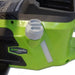 Close-up of the Greenworks 40V Brushless Chainsaw showing its green body, black vent panel, and white oil cap near the handle. Photographed on a light background, focusing on the side controls and sturdy ergonomic build of the cordless chainsaw.