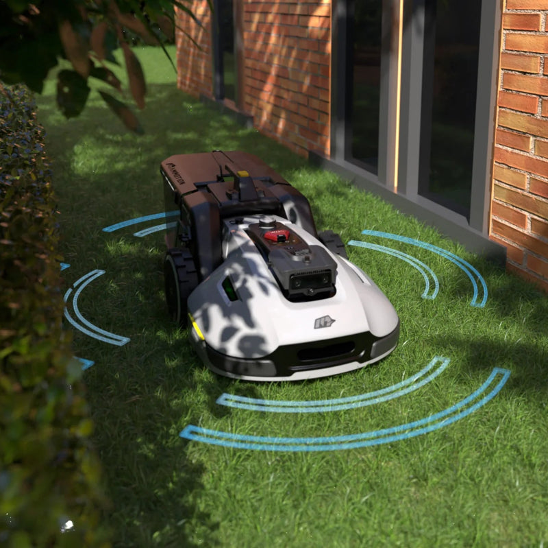 A Mammotion YUKA robotic mower operates on grass beside a brick house wall and hedge, with blue sensor waves illustrating its smart navigation and obstacle detection under soft daylight.