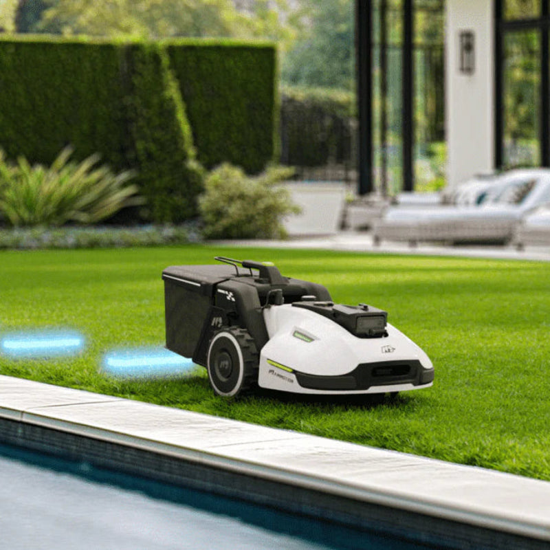 Mammotion Yuka robotic lawn mower automatically mapping and mowing near a swimming pool, with blue guidance lines visible on the grass, and a modern house with outdoor seating in the background.