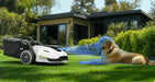 Mammotion Yuka robotic mower on a lawn using AI vision to detect and avoid a golden retriever lying in the grass, with a modern house and garden greenery in the background.