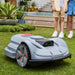 Moebot Acre Eater robotic lawn mower operating autonomously on a neatly trimmed lawn, with modern design and LED sensors visible at the front.