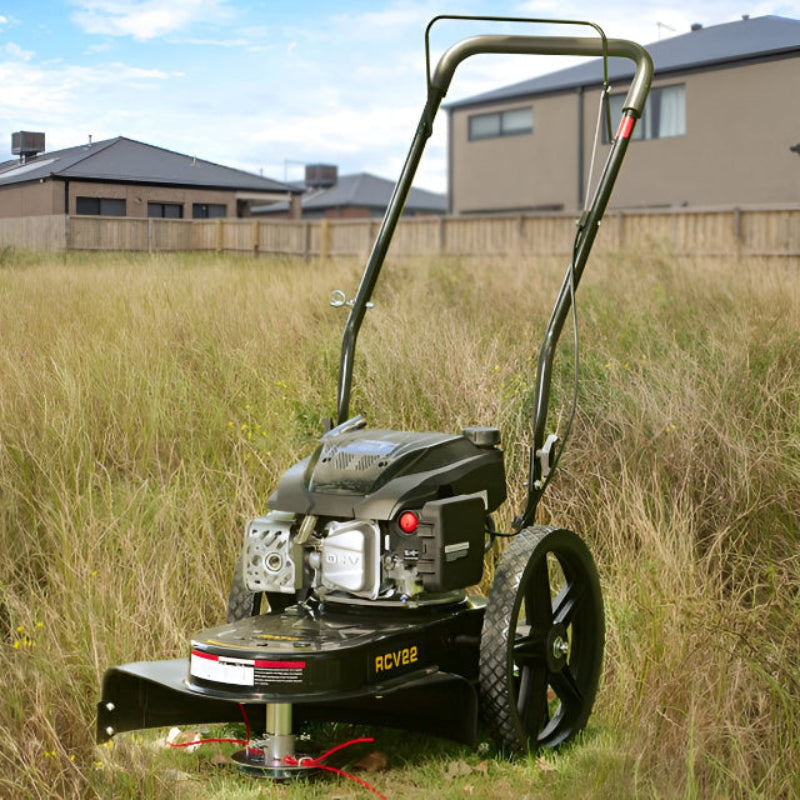 Rato RCV22 high wheel trimmer in action cutting tall grass in a residential backyard. Features durable OHV engine, wide wheels, and heavy-duty deck. Ideal for clearing overgrown areas, long weeds, and rough terrain where regular mowers struggle.