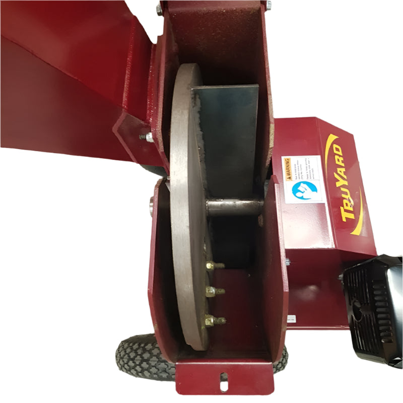 The part of the machine shown in the image is the flywheel and cutting blade assembly of a wood chipper, specifically a Truyard C100 Chipper. 