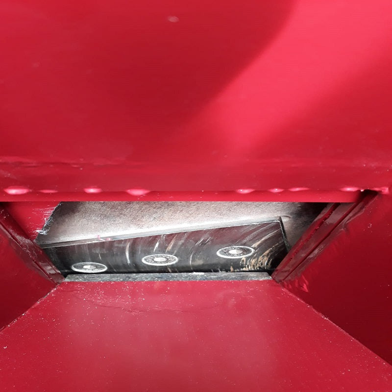 The image shows the internal mechanism of a chipper, specifically the cutting blades and the chute through which material is fed or processed.