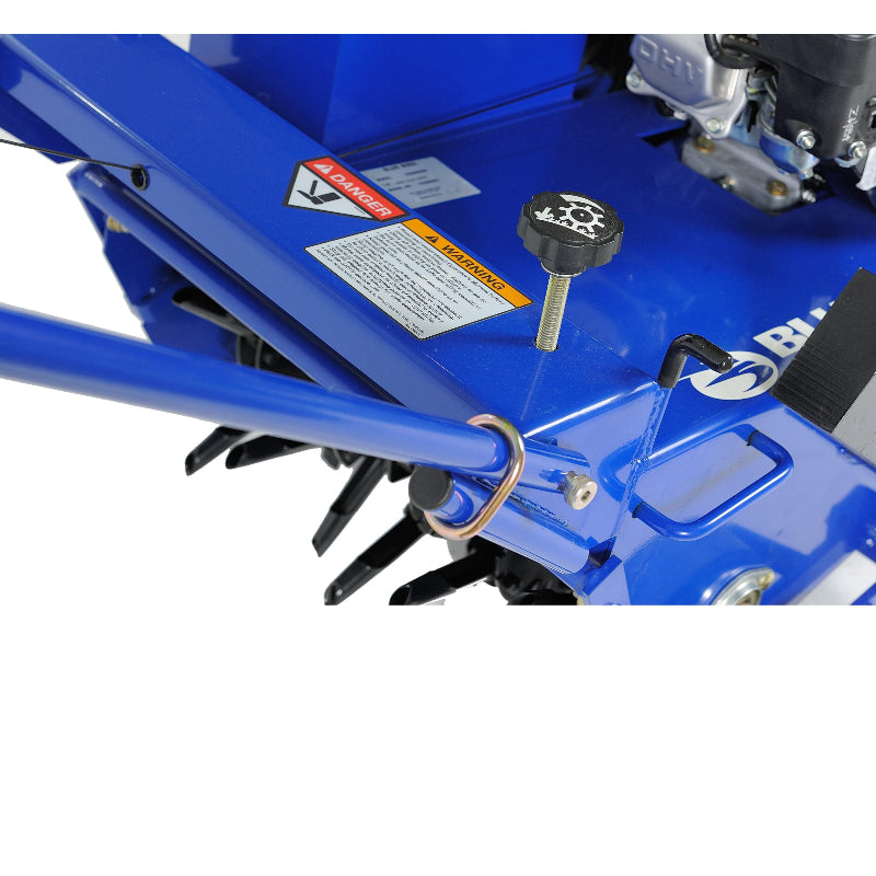 Close-up view of Crommelins 530HP Bluebird 19-inch lawn aerator, showing blue steel frame, adjustment knob, warning labels, and visible coring tines beneath, photographed on a plain white background for detailed inspection of controls and components.